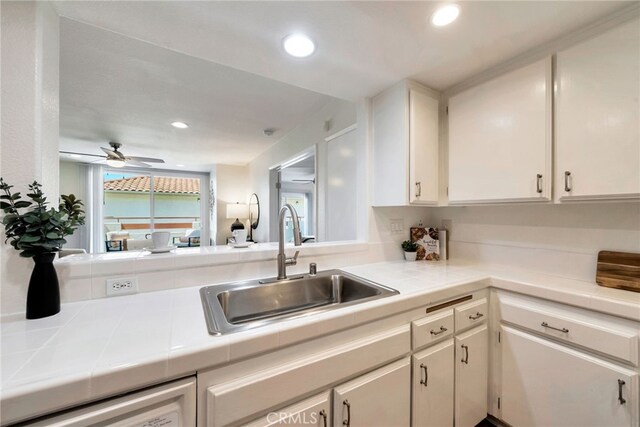 kitchen featuring a sink, recessed lighting, white cabinetry, a ceiling fan, and tile countertops
