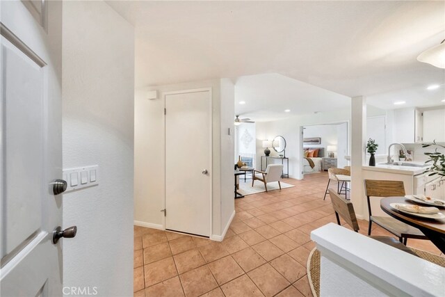 interior space with recessed lighting, baseboards, a sink, and light tile patterned floors
