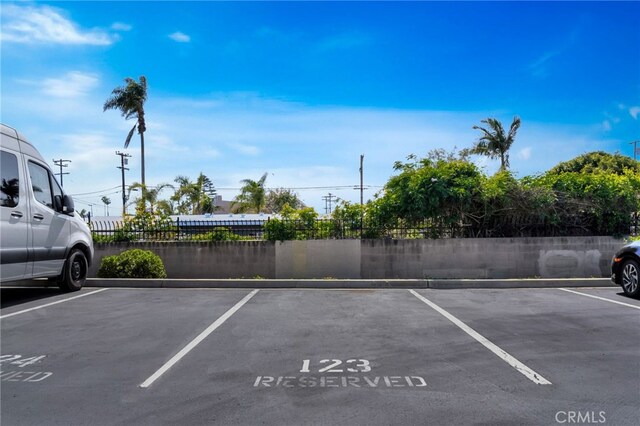 uncovered parking lot featuring fence