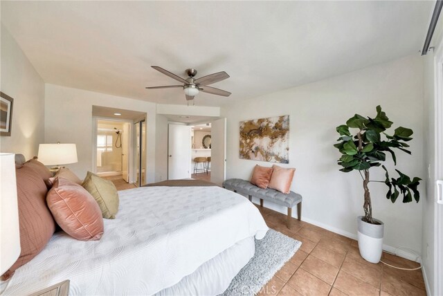 bedroom with light tile patterned flooring, baseboards, ceiling fan, and ensuite bathroom