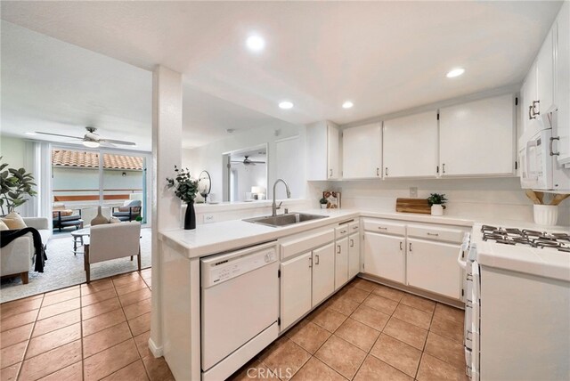 kitchen featuring light countertops, white appliances, a sink, and ceiling fan