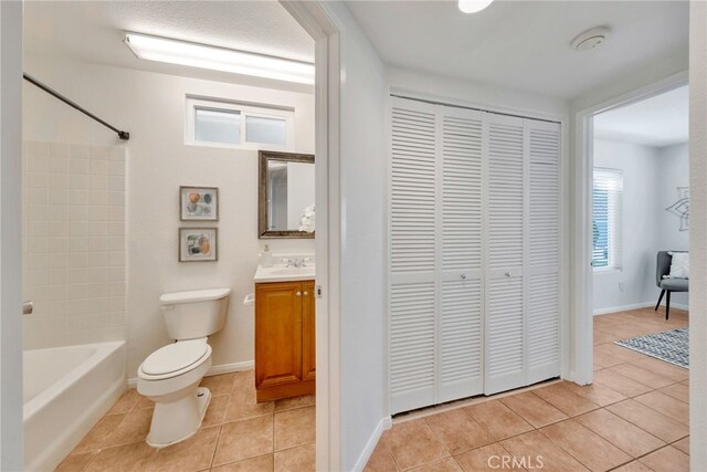 full bath featuring a closet, tile patterned flooring, vanity, and toilet