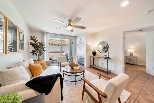 living area featuring light tile patterned flooring, baseboards, ceiling fan, and recessed lighting