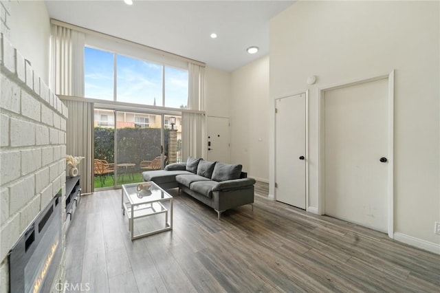 living room featuring recessed lighting, wood finished floors, and baseboards