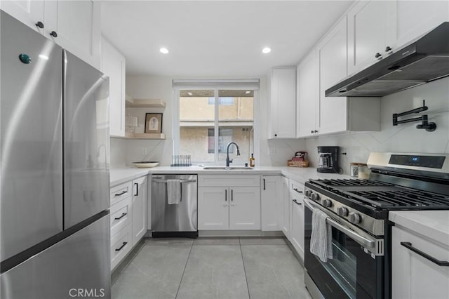 kitchen with white cabinets, under cabinet range hood, light countertops, a sink, and appliances with stainless steel finishes