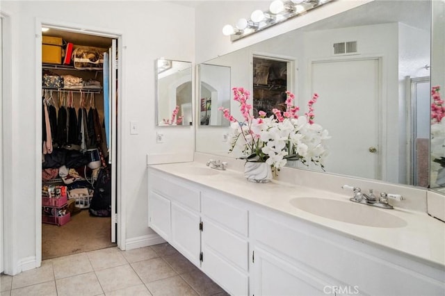 full bathroom featuring a spacious closet, tile patterned flooring, a sink, and visible vents