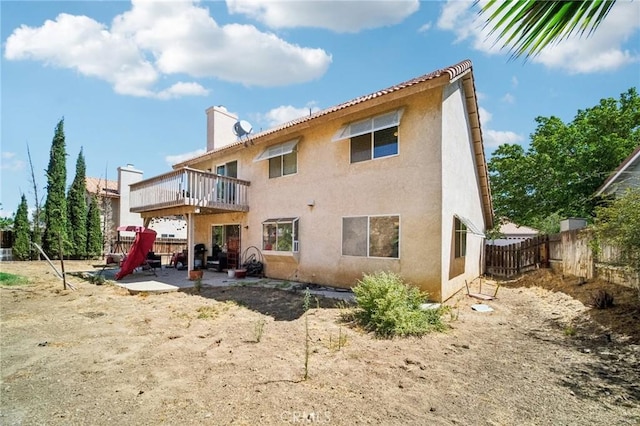 rear view of property featuring fence, a patio, a chimney, and stucco siding