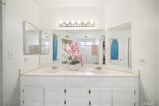 bathroom featuring double vanity, visible vents, and a sink