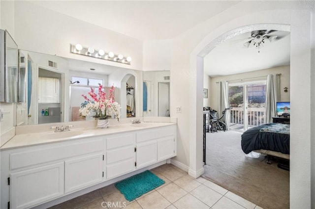 ensuite bathroom featuring tile patterned flooring, double vanity, visible vents, a sink, and ensuite bath