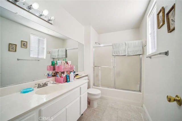 bathroom with a healthy amount of sunlight, tile patterned floors, vanity, and toilet