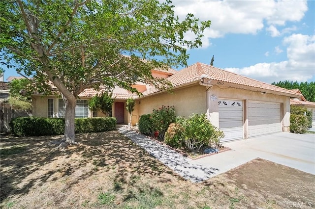 ranch-style home featuring a garage, driveway, a tiled roof, and stucco siding