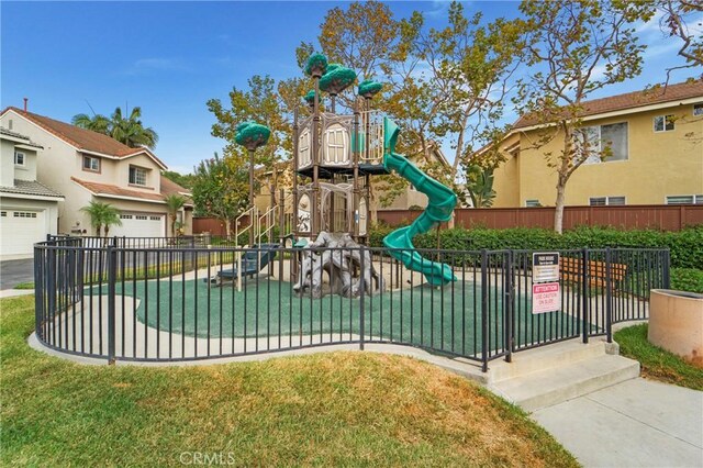 community playground featuring a lawn and fence