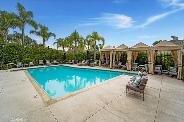 community pool with a gazebo, an outdoor living space, and a patio area