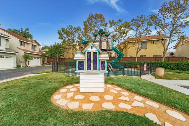 view of jungle gym with a yard, a residential view, and fence