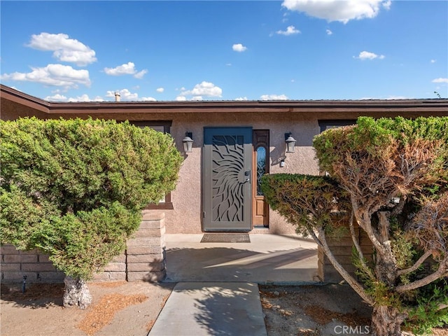 view of exterior entry with stucco siding