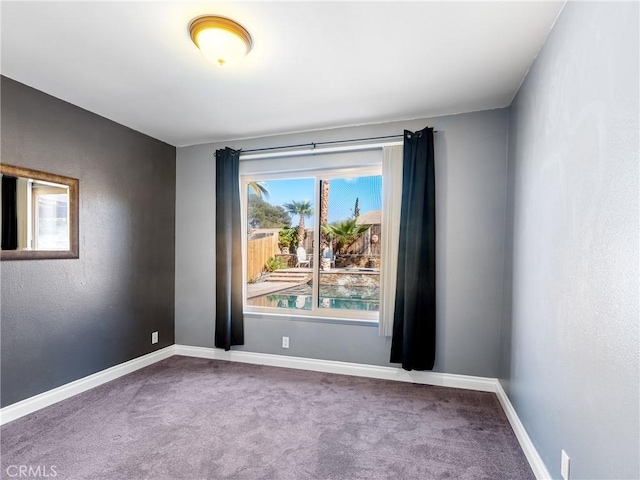 carpeted spare room with baseboards
