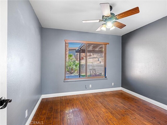 spare room featuring ceiling fan, baseboards, and hardwood / wood-style floors