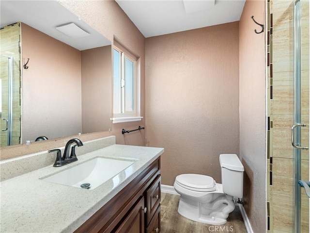 full bath with a shower stall, toilet, vanity, and wood finished floors