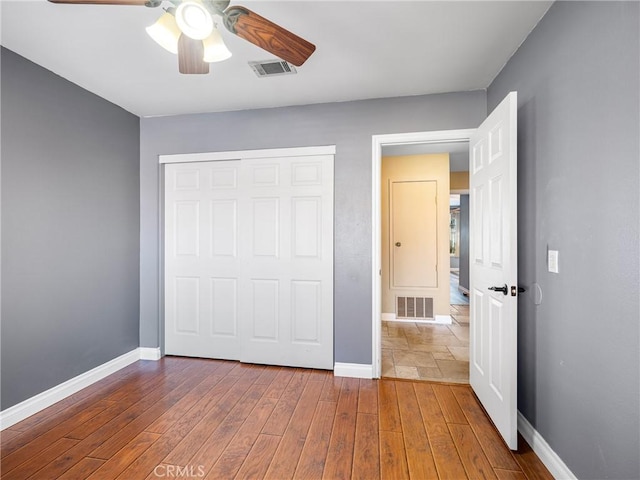 unfurnished bedroom with baseboards, visible vents, and a closet
