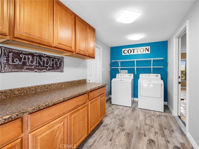 clothes washing area with separate washer and dryer, baseboards, light wood finished floors, and cabinet space