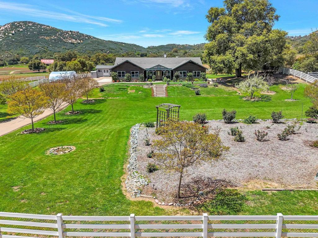 exterior space featuring a front lawn, a mountain view, and fence