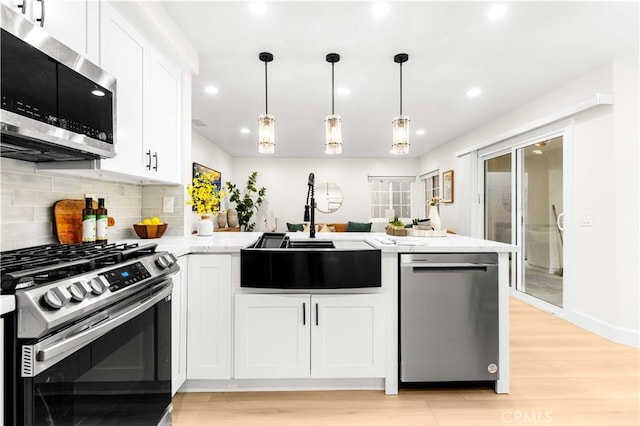 20163 Corona St, Corona, CA 92881 - kitchen with stainless steel appliances, a sink, a peninsula, light wood-type flooring, and recessed lighting