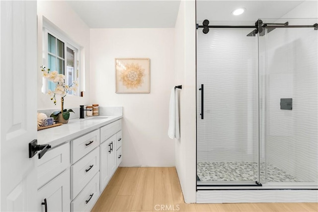 full bathroom featuring recessed lighting, a shower stall, wood finished floors, and vanity