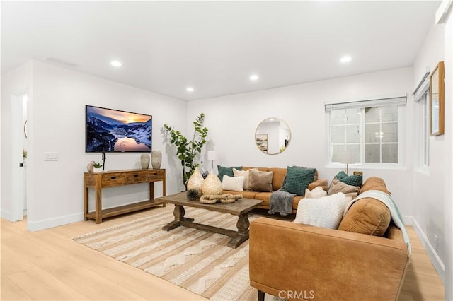 living area featuring recessed lighting, baseboards, and light wood-style floors