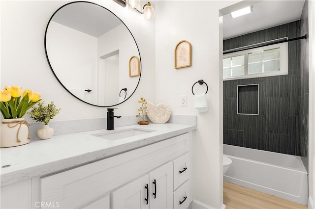 full bath with toilet, wood finished floors, and vanity