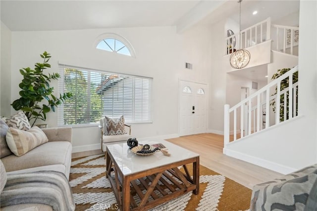 20163 Corona St, Corona, CA 92881 - living area with wood finished floors, baseboards, a chandelier, high vaulted ceiling, and stairs