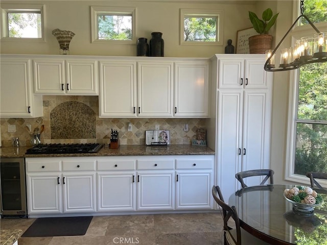 9 Pembroke Ln, Laguna Niguel, CA 92677 - kitchen with black gas stovetop, beverage cooler, tasteful backsplash, white cabinets, and dark stone countertops