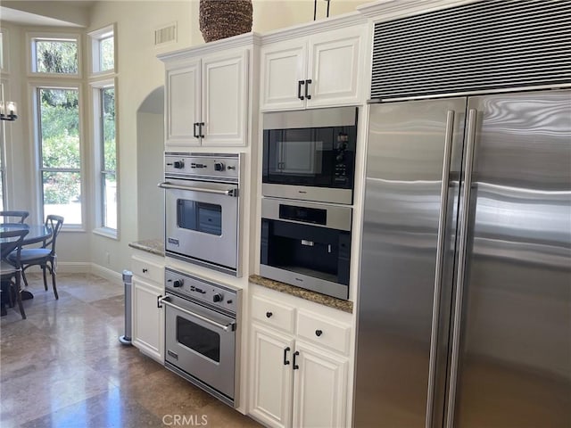 9 Pembroke Ln, Laguna Niguel, CA 92677 - kitchen with built in appliances, plenty of natural light, light stone countertops, and baseboards