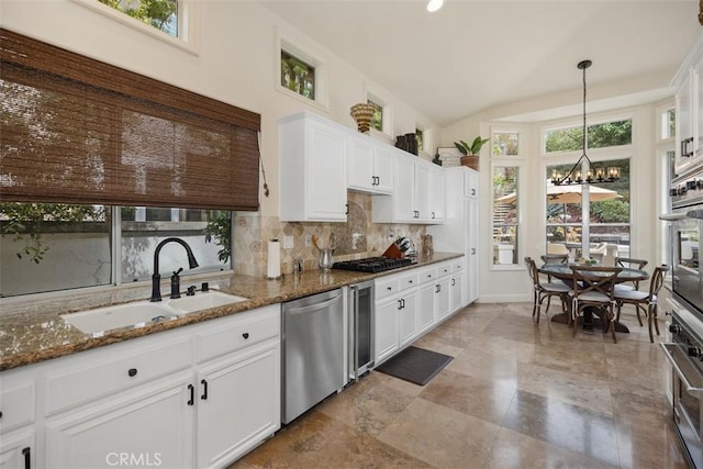 9 Pembroke Ln, Laguna Niguel, CA 92677 - kitchen with appliances with stainless steel finishes, a sink, a chandelier, beverage cooler, and backsplash