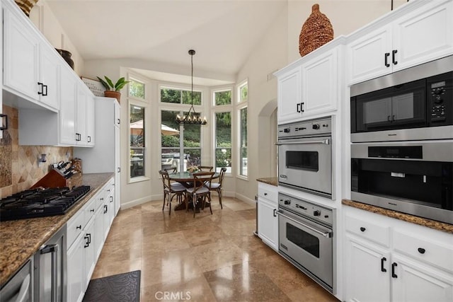 9 Pembroke Ln, Laguna Niguel, CA 92677 - kitchen featuring a chandelier, appliances with stainless steel finishes, decorative backsplash, white cabinets, and vaulted ceiling