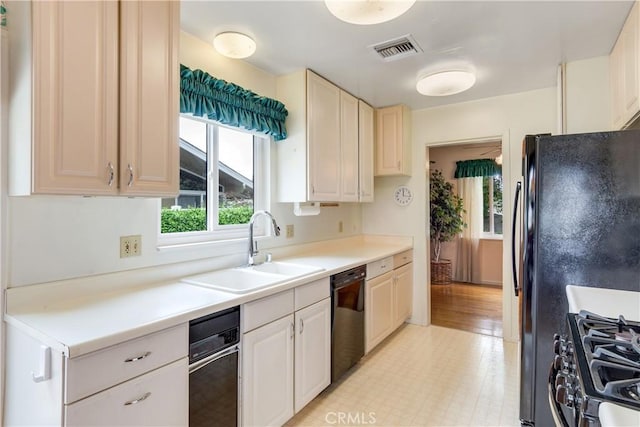 kitchen with light countertops, stainless steel range with gas stovetop, visible vents, a sink, and black dishwasher
