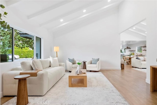 living area featuring recessed lighting, wood finished floors, baseboards, and lofted ceiling with beams