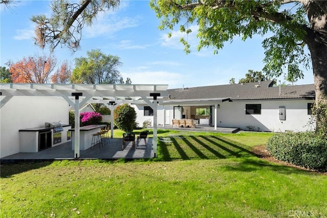 rear view of property featuring area for grilling, a pergola, stucco siding, a patio area, and a lawn