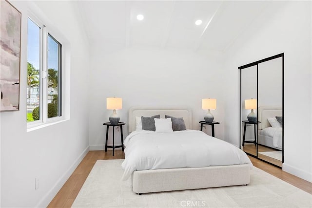 bedroom with recessed lighting, wood finished floors, baseboards, and beamed ceiling