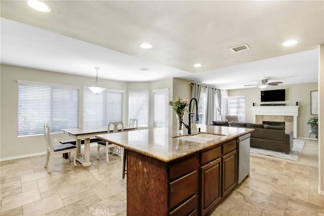 kitchen featuring a sink, stainless steel dishwasher, stone tile flooring, and visible vents