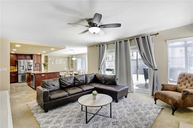 living area featuring ceiling fan, light carpet, and recessed lighting