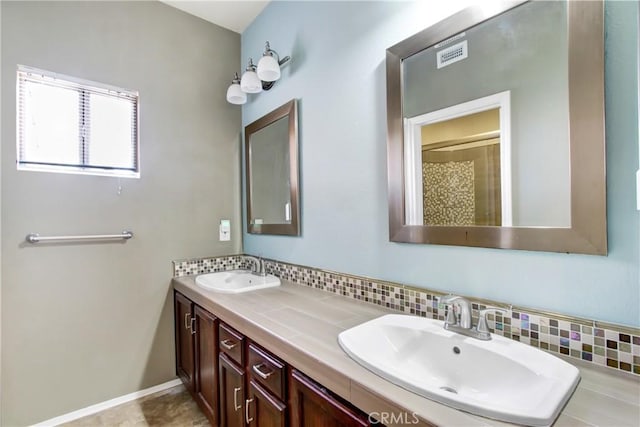 full bathroom featuring a sink, backsplash, double vanity, and visible vents