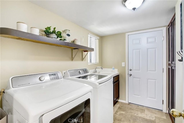 laundry area featuring baseboards, a sink, cabinet space, and washing machine and clothes dryer