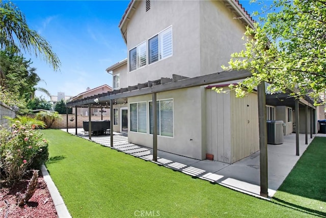rear view of house with a pergola, stucco siding, a fenced backyard, a patio area, and a yard