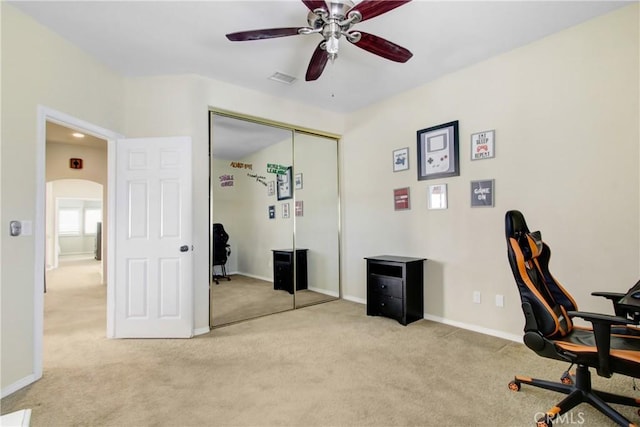 carpeted office featuring arched walkways, ceiling fan, baseboards, and visible vents