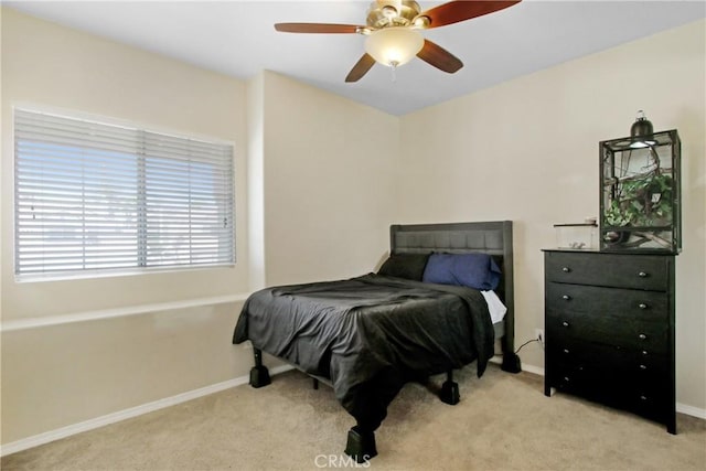 carpeted bedroom featuring baseboards and ceiling fan
