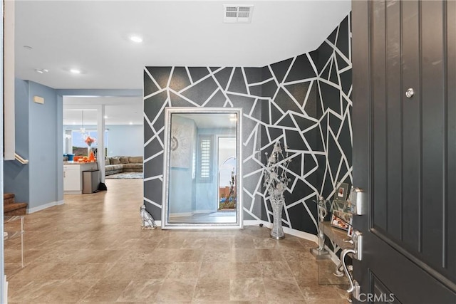 entrance foyer featuring visible vents, stone finish flooring, baseboards, and stairs