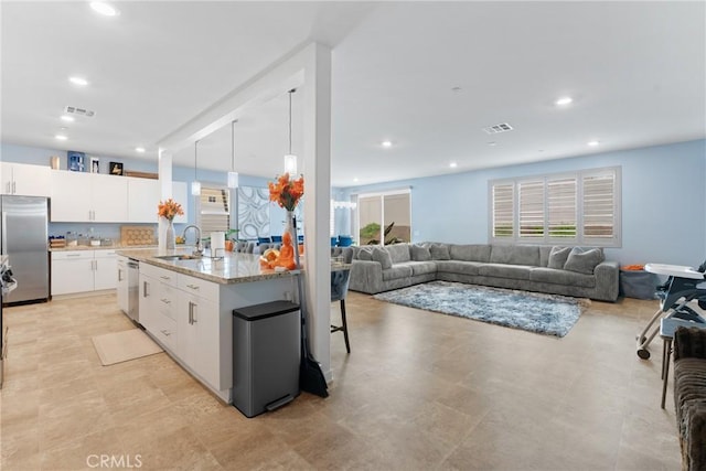 kitchen with a sink, a healthy amount of sunlight, stainless steel appliances, and visible vents