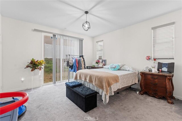 carpeted bedroom featuring baseboards and access to exterior
