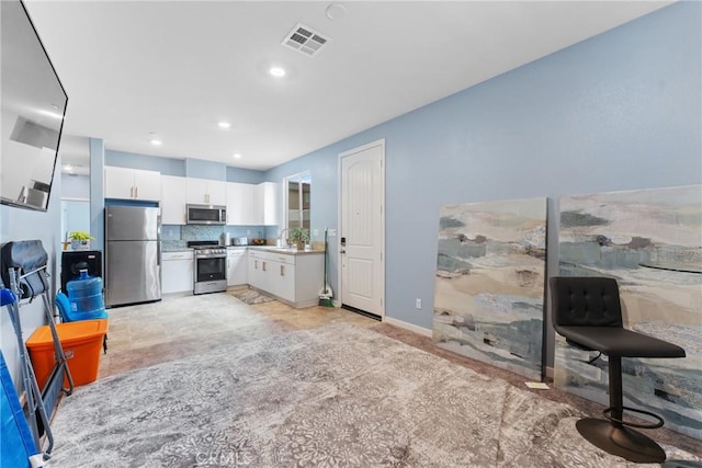 kitchen featuring visible vents, light countertops, white cabinets, a sink, and stainless steel appliances