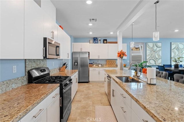 kitchen featuring a sink, light stone countertops, stainless steel appliances, and visible vents